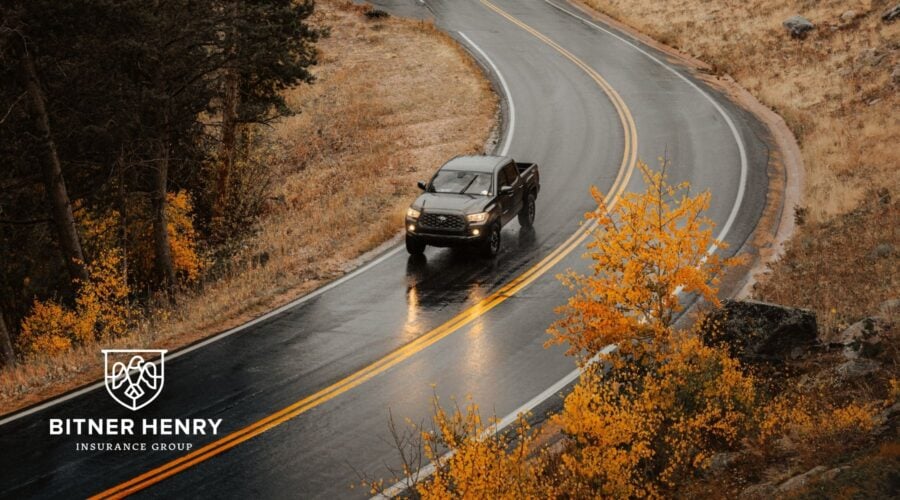 a car drives safely down the road. the bitner henry logo is in the bottom left.