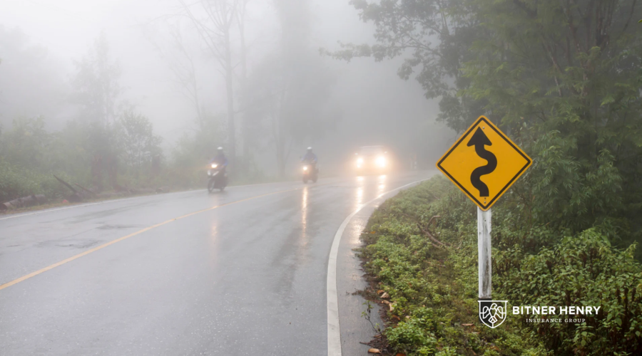 Motorcycles drive down a rainy road. The Bitner Henry logo is in the bottom right.