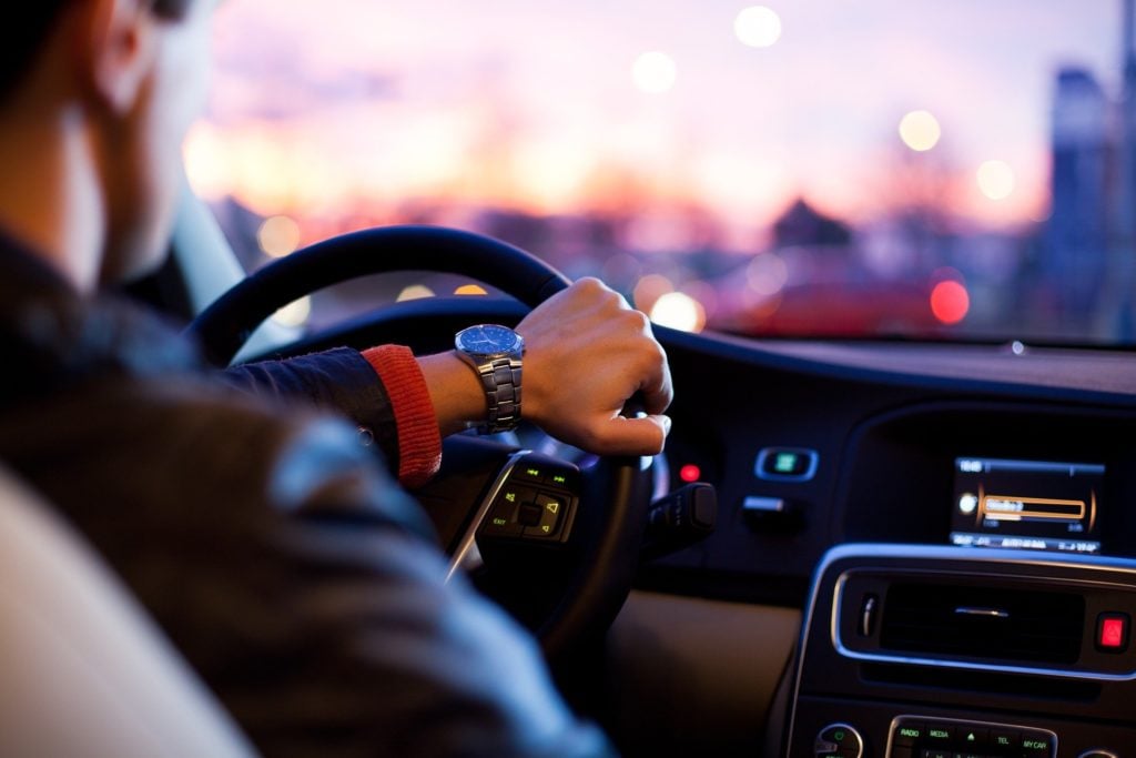 Man driving a car wearing a silver watch 