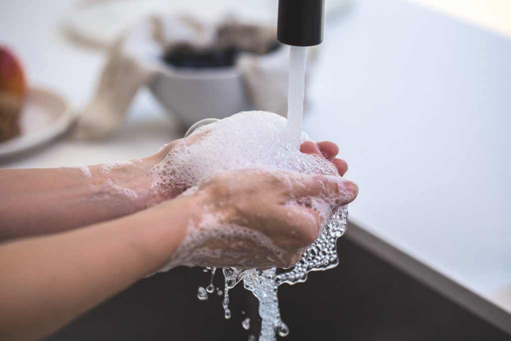 Person washing hands at sink