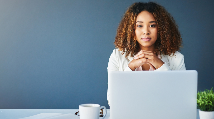 young woman sitting at laptop and looking at the camera