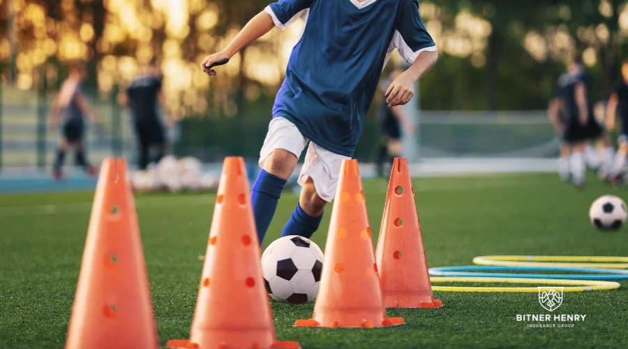 A child plays soccer on the green. The Bitner Henry logo is on the bottom right.
