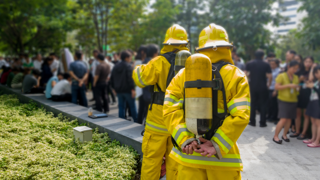 two firefighters in yellow uniforms with their back to the camera. 