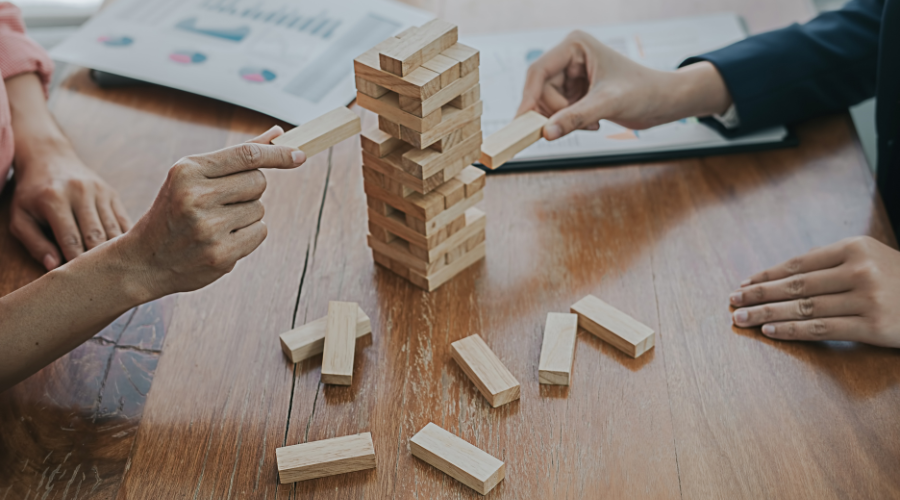 Two people playing with Jenga block tower