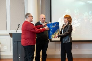 Bruce Harriman receives a gift from Carol and Steve Henry
