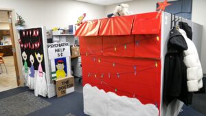 The Marketing cubicle decorated as a Charlie Brown Christmas, complete with Snoopy's doghouse, a choir of singing children, and Lucy's psychiatric help stand