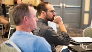 Lee Harrison, a school insurance agent, listens intently to a presentation
