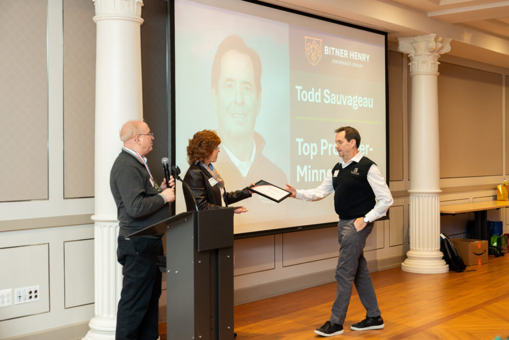Todd Sauvageau accepts an award from Carol and Stephen Henry