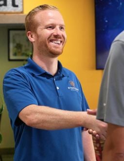 Andrew Henry Shakes Hands Andrew Henry, an insurance agent, shakes someone's hand in a small business.