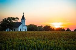 Church A church stands in a field at sunset.