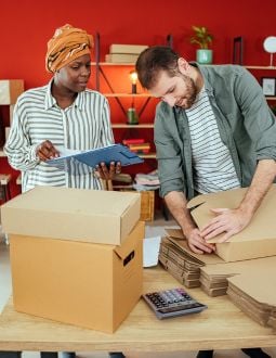 A man and a woman set up boxes together