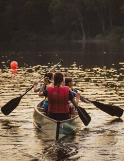 canoeing people (1) a camp counselor and camper canoe through a lake