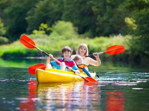 family in a canoe A child and a camp counselor canoe down a river.