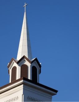 steeple A church steeple in front of a blue sky