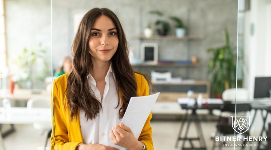 An independent contractor holds a clipboard and smiles