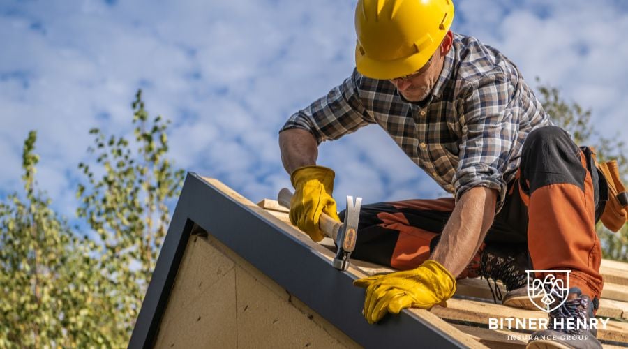 A man fixes a house with the Bitner Henry logo in the bottom right