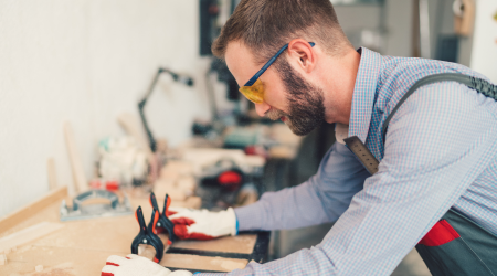 A carpenter measures a piece of wood