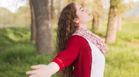 A woman spreads her arms to embrace healing and freedom after an inpatient treatment program