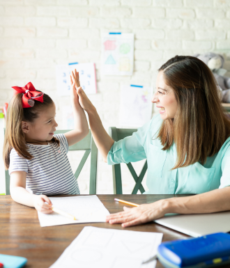 School Bus (5) A mom high-fives her daughter while they homeschool together