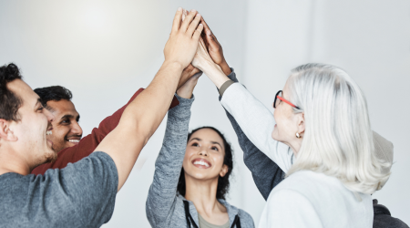 People high-five A group of people recover together, putting their hands together above their heads
