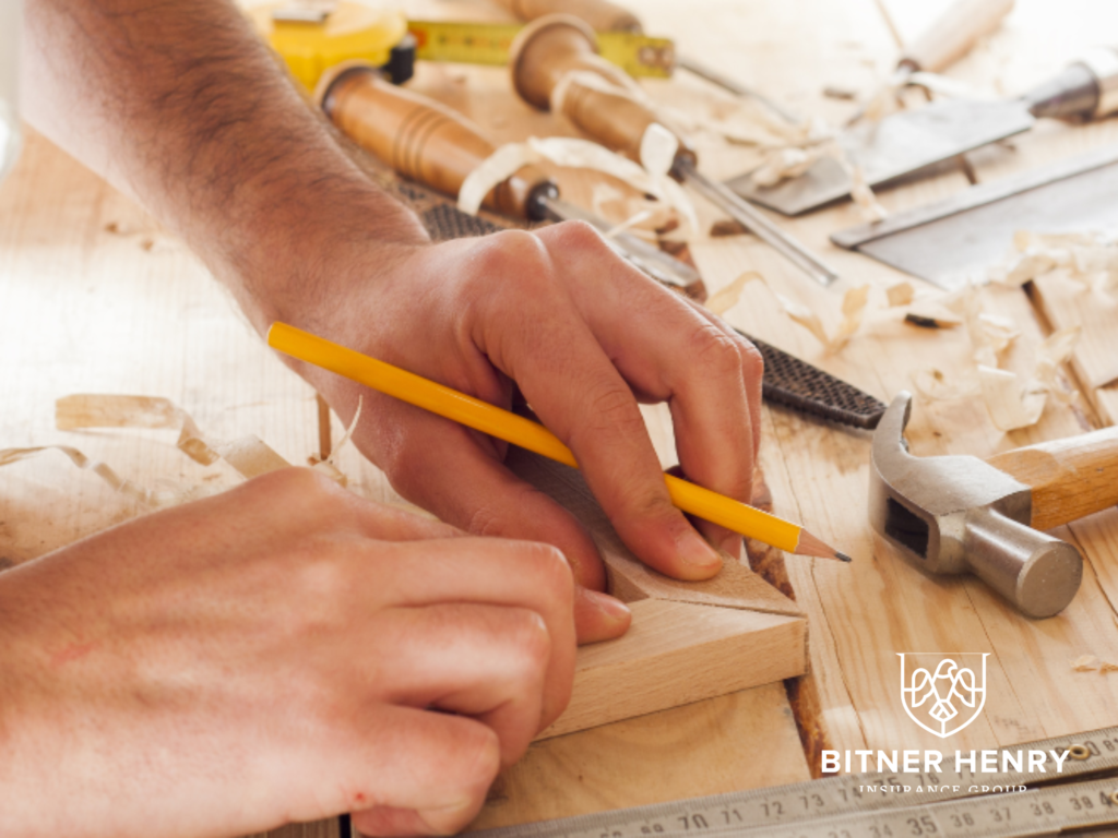 A carpenter puts wood together with a pencil in his hand