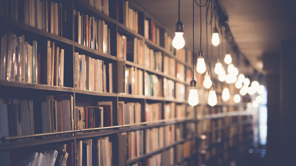 A library with several lightbulbs hanging down off the ceiling