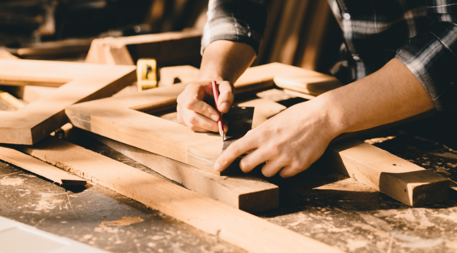 A carpenter works on some wood with nails, with Maryland carpenter insurance coverage