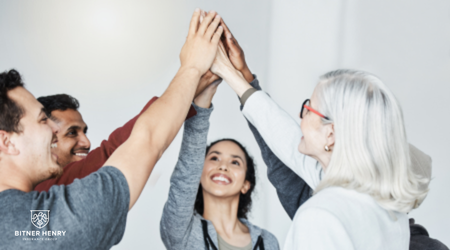 A group of people recover together, putting their hands together above their heads