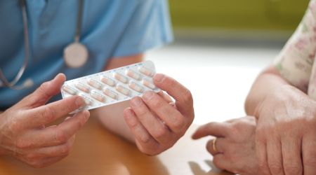 A nurse offers helping medication to a recovery patient