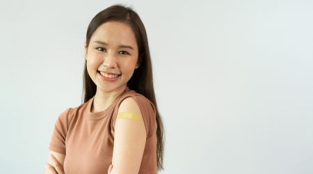 A recovering woman with a bandage on her arm smiles