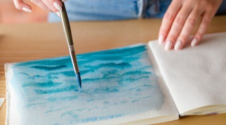 therapy programs (2) Someone paints calming blue waves on a paper in therapy