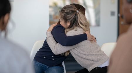 Two people embrace each other, healing