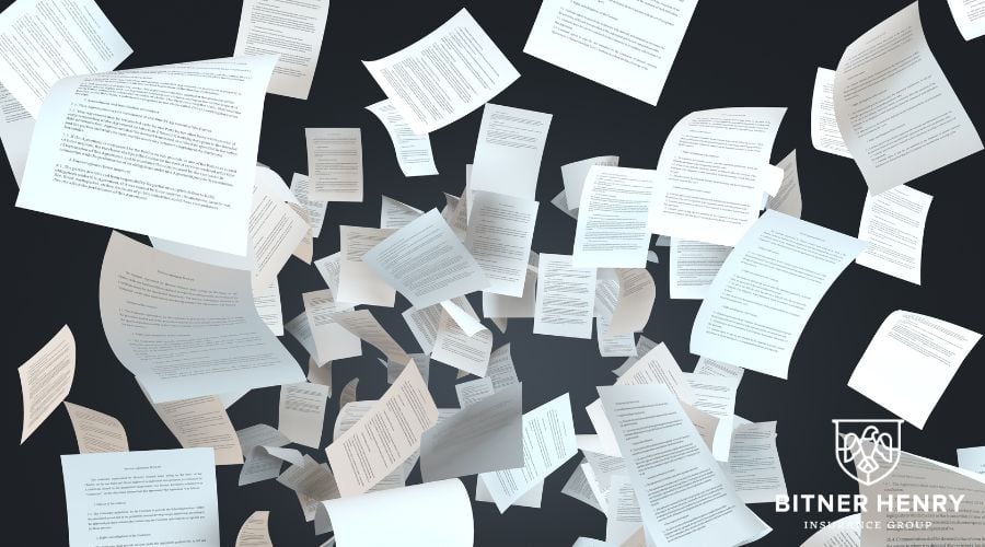 Papers and contracts with the bitner henry logo in the back