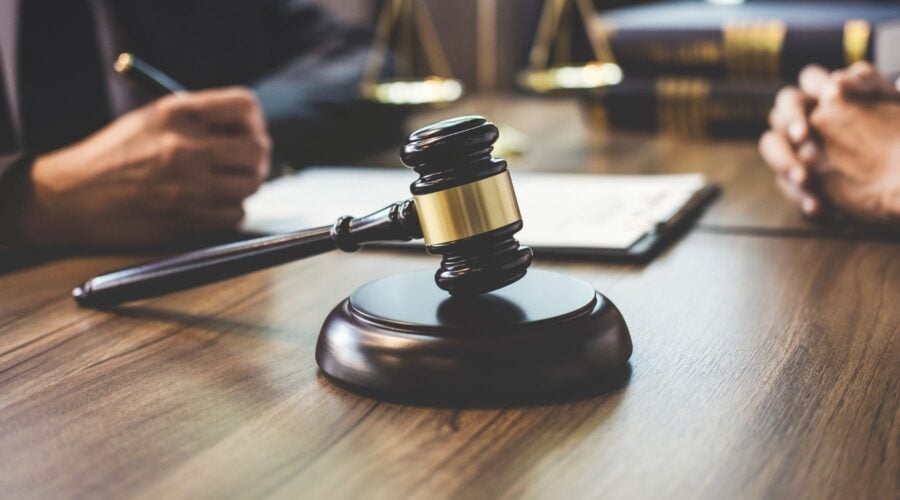 A legal gavel with lawyers