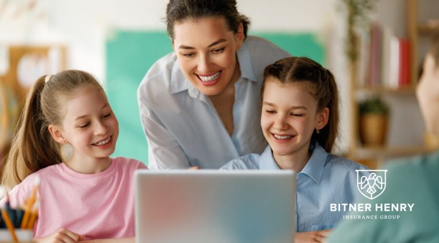 Happy schoolchildren with a laptop- the Bitner Henry Insurance Group logo is in the bottom-left.