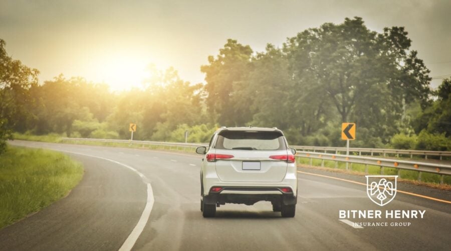 A car drives down the road safely. The Bitner Henry logo is in the bottom right.