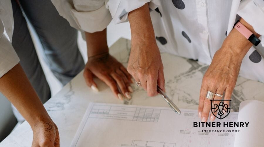 People examine a blueprint for their school to make the access points safer. The Bitner Henry logo is in the bottom right.