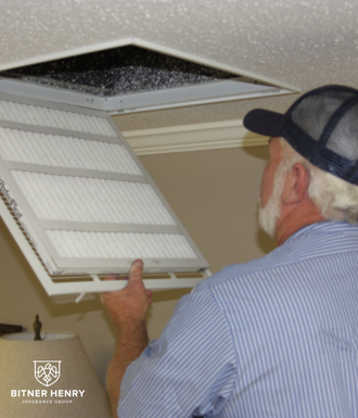 hvac guy replaces an air filter in a vent