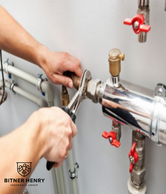 A plumber uses a wrench to fix a pipe