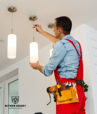 An electrician installs lights in a kitchen