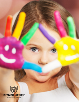 A child with face-painted hands holds them up to the camera