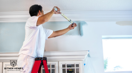 A man paints a wall with a paint roller