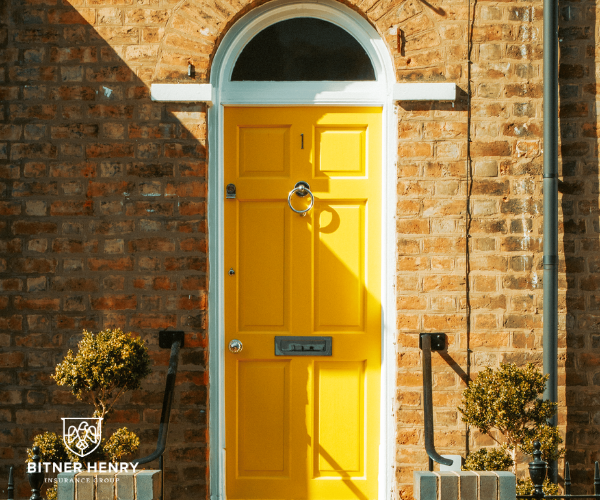 A yellow door to a property, with the bitner henry logo in the bottom left.