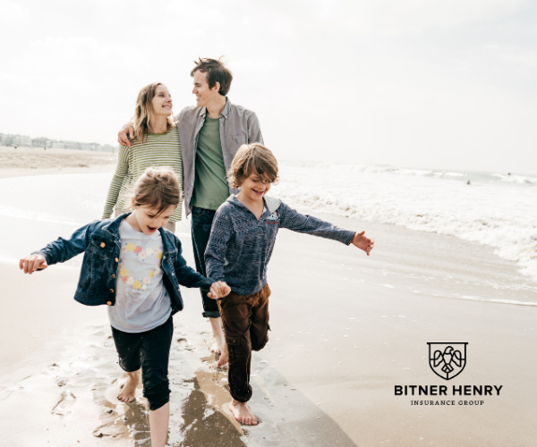 A family lovingly walks down the beach. The Bitner Henry logo is in the bottom right.