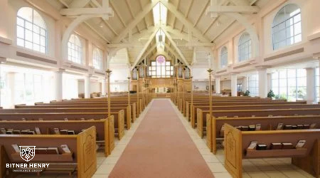 The inside of a church, complete with pews, glass windows, and more. The Bitner Henry logo is in the bottom left.