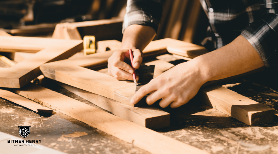 A carpenter cuts wood to size and measures things. The Bitner Henry logo is in the bottom left.