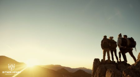 A group of intensive outpatient recovery patients celebrate recovery by watching the sun from a mountain