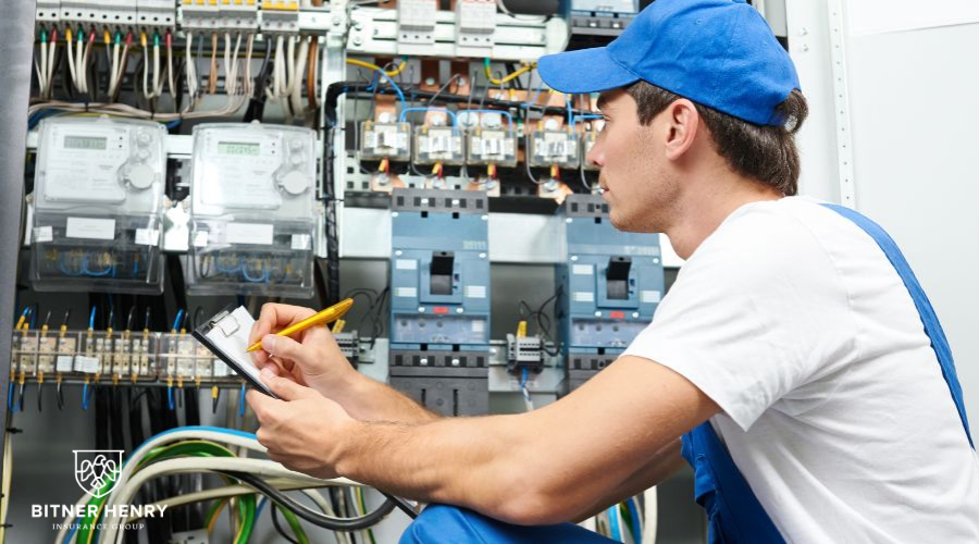 An electrician works on a wall of servers