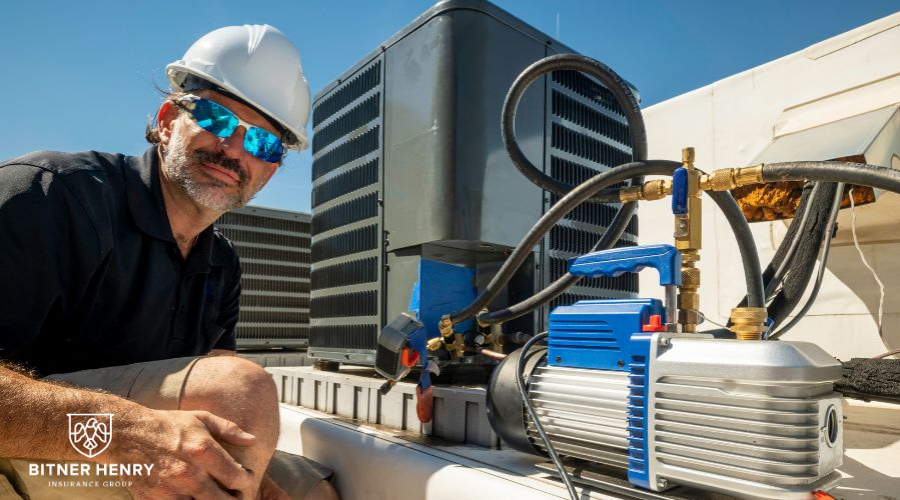 An HVAC technician works on a rooftop repair. The Bitner Henry logo is in the bottom-left.