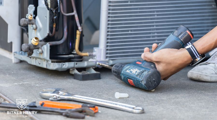 An HVAC Contractor installs an HVAC unit with a drill